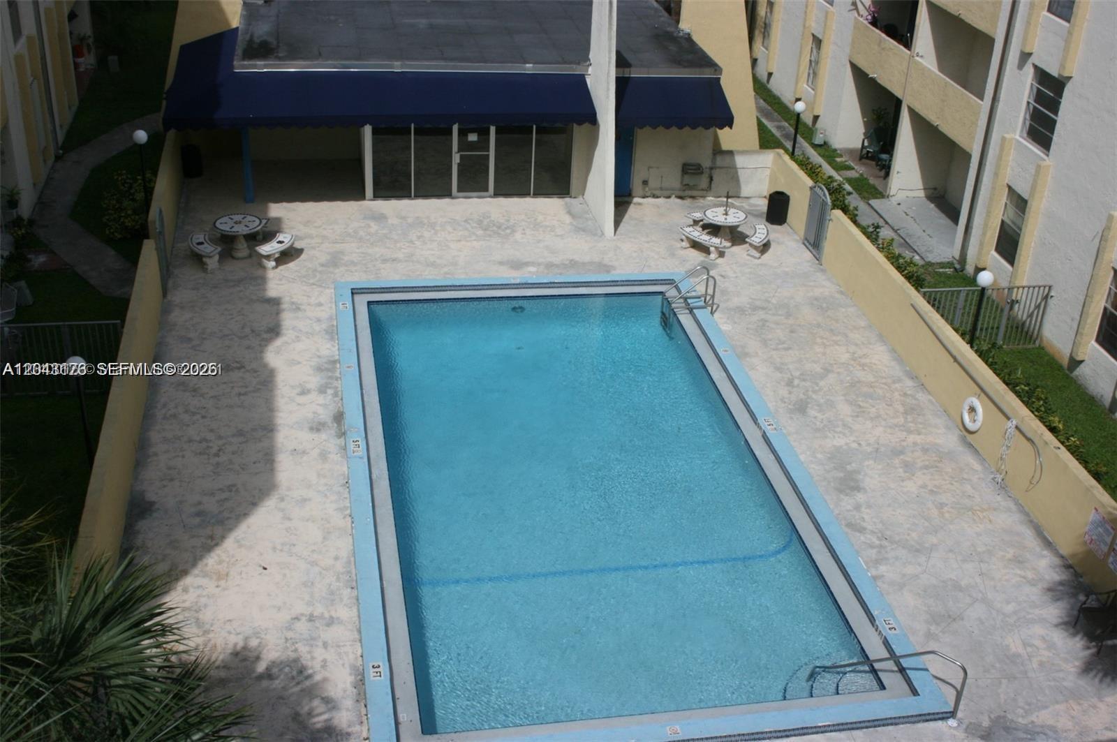 An aerial view of a rectangular swimming pool surrounded by a concrete deck and patio furniture — 10000 NW 80th St # 2147, Hialeah Gardens FL 33016, HIALEAH GARDENS, FL