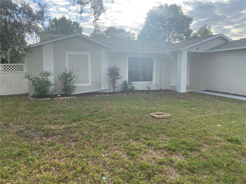 A single-story house with a light-colored exterior, a front lawn, and a covered entryway — 2459 LANDOVER BOULEVARD, SPRING HILL, FL