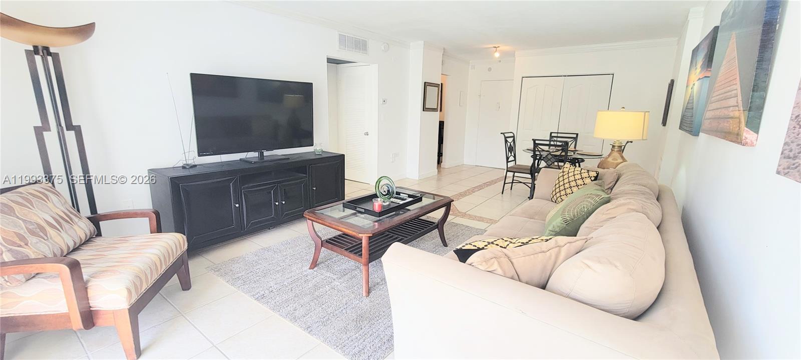 A living room features a beige sofa, a black media console, and a glass coffee table — 400 S Kings Point Dr # 220, Sunny Isles Beach FL 33160, SUNNY ISLES BEACH, FL