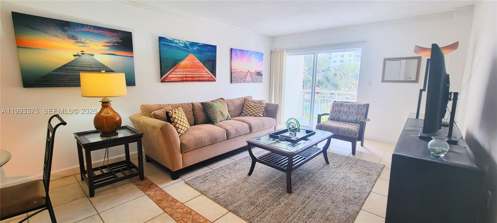 A living room features a beige sofa, a glass coffee table, and three landscape wall canvases — 400 S Kings Point Dr # 220, Sunny Isles Beach FL 33160, SUNNY ISLES BEACH, FL