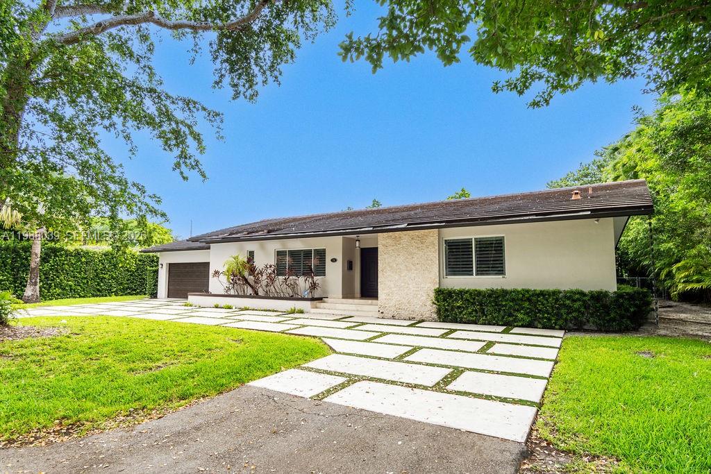A single-story house with a white exterior, stone accent wall, and a paved driveway — 75 S Prospect Dr, Coral Gables FL 33133, CORAL GABLES, FL