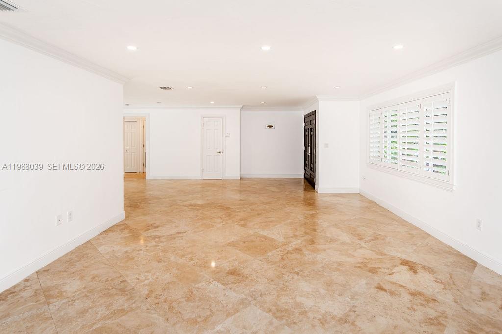 An empty room features white walls, recessed lighting, and polished tan tile flooring — 75 S Prospect Dr, Coral Gables FL 33133, CORAL GABLES, FL
