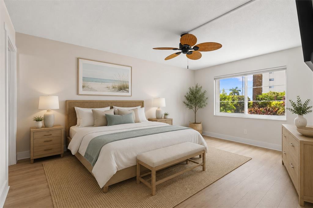A bedroom features a king bed, wooden furniture, a ceiling fan, and a large window — 5600 BEACH WAY DRIVE UNIT 109, SARASOTA, FL