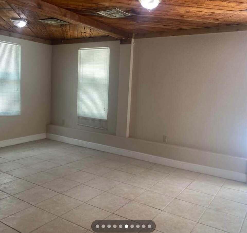 An empty room with light-colored tile flooring, beige walls, and a wood-paneled ceiling — 952 30th Street, West Palm Beach FL 33407, WEST PALM BEACH, FL