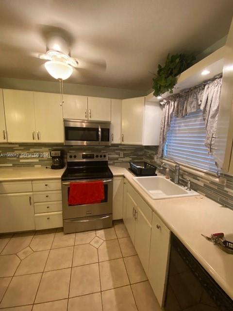 A kitchen with white cabinets, stainless steel appliances, a tiled backsplash, and light-colored countertops — 5100 SW 64th Ave # 202, Davie FL 33314, DAVIE, FL
