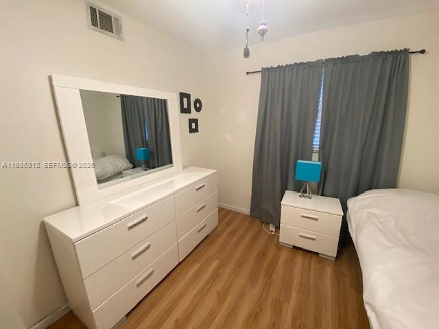 A bedroom features a white dresser with a mirror, a nightstand, and gray curtains — 5100 SW 64th Ave # 202, Davie FL 33314, DAVIE, FL