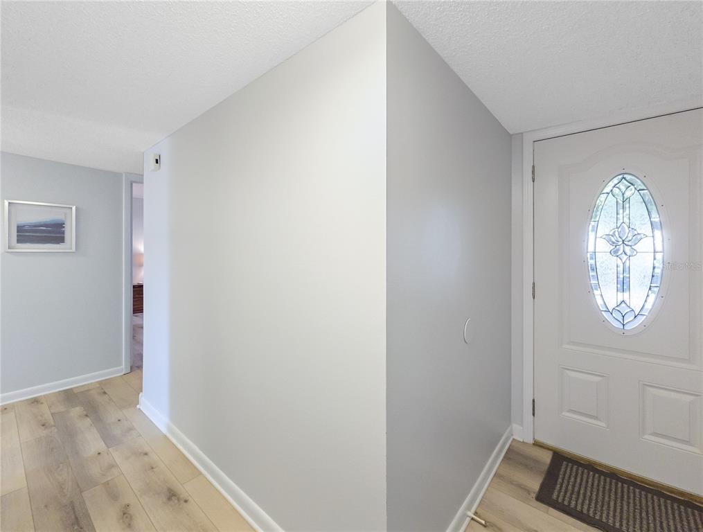 An entryway features light gray walls, wood-look flooring, and a white door with glass inlay — 646 MIDWAY DRIVE UNIT A, OCALA, FL