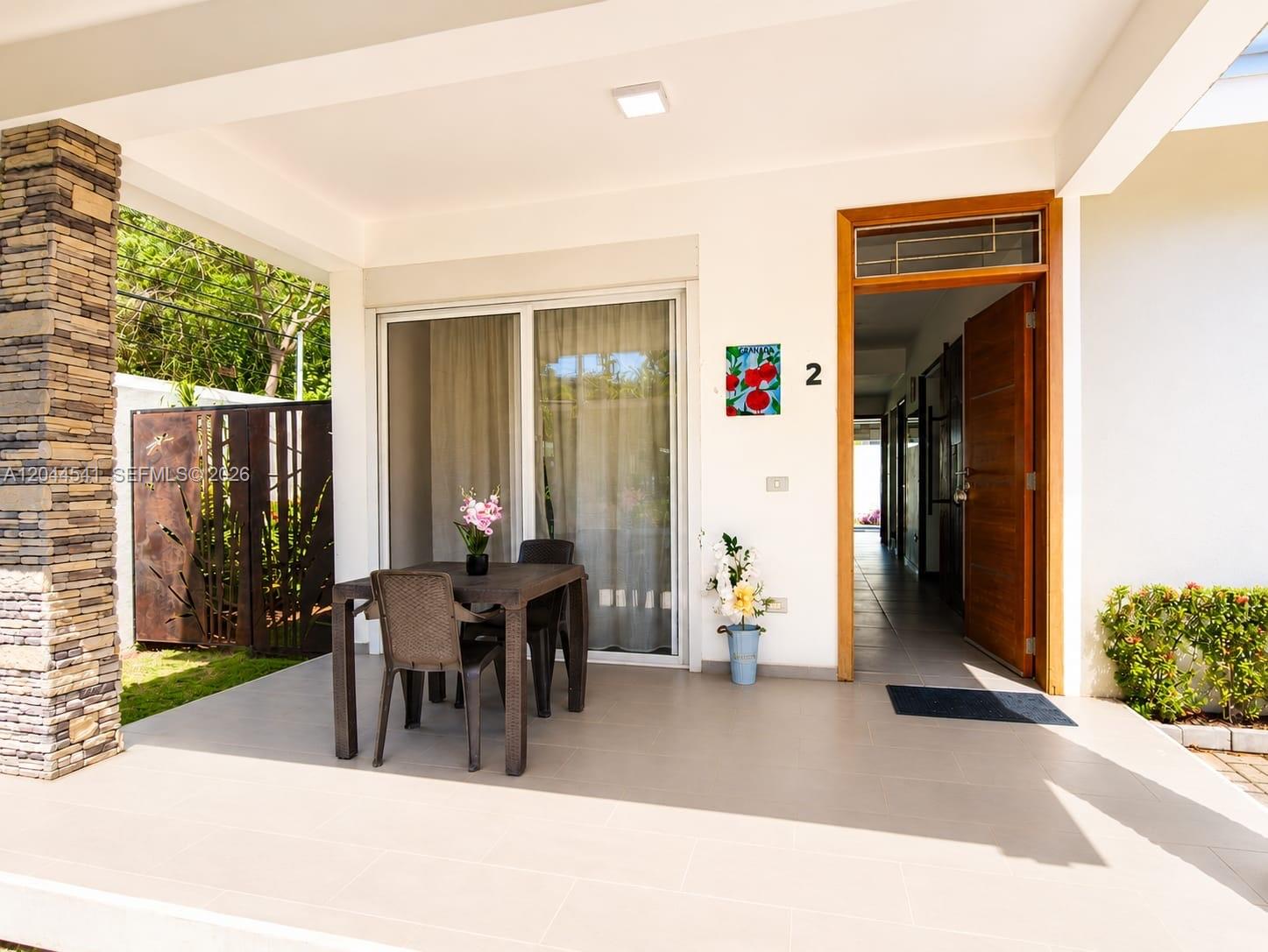 A covered patio features a dining set, a doorway, and a stone-clad pillar — oo CALLE MARIANO VANDERHORST, FL 32000, FL