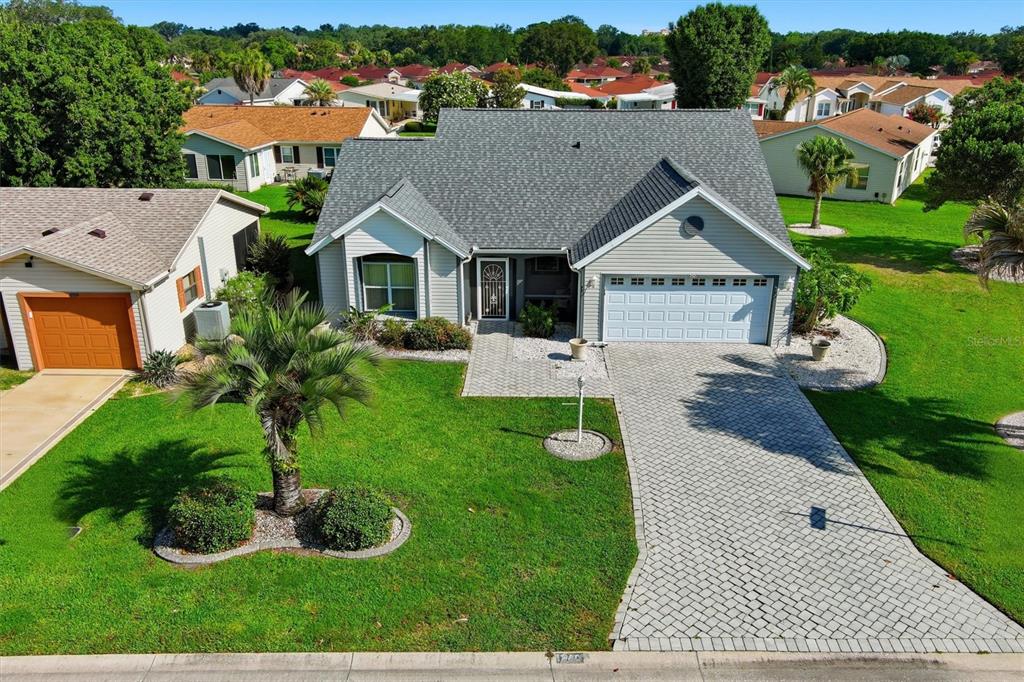 An aerial view of a single-story house with a gray roof and paved driveway — 1260 GRANADA COURT, LADY LAKE, FL