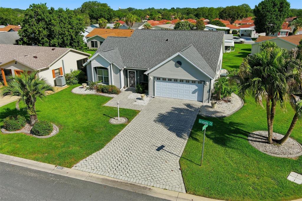 An aerial view of a single-story house with a gray roof and paved driveway — 1260 GRANADA COURT, LADY LAKE, FL