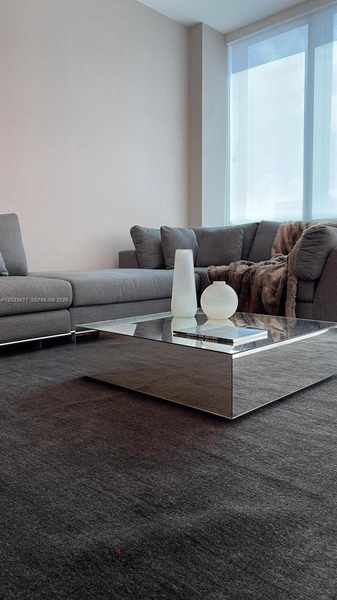 A living room features a gray sectional sofa, a mirrored coffee table, and large windows — 121 NE 5th St # 2102, Miami FL 33132, MIAMI, FL