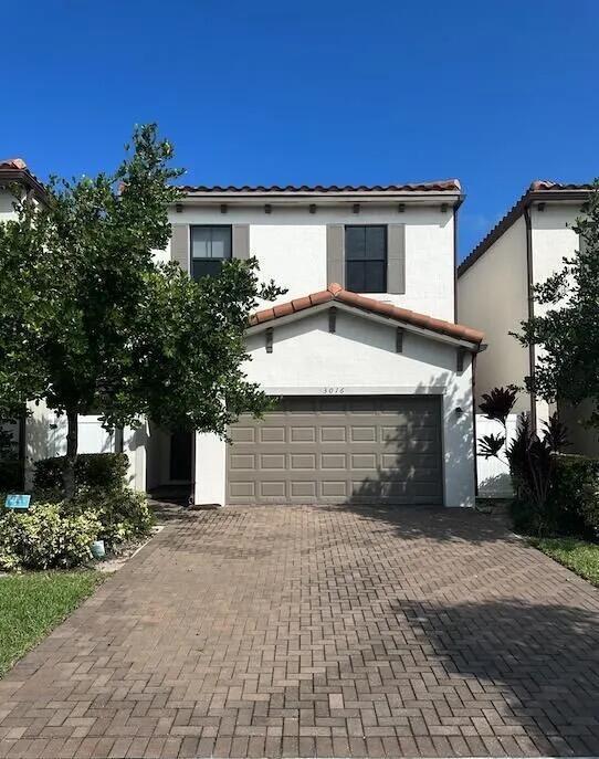 A two-story house with a white exterior, a brown garage door, and a paved driveway — 3016 King Palm Way, Riviera Beach FL 33410, RIVIERA BEACH, FL