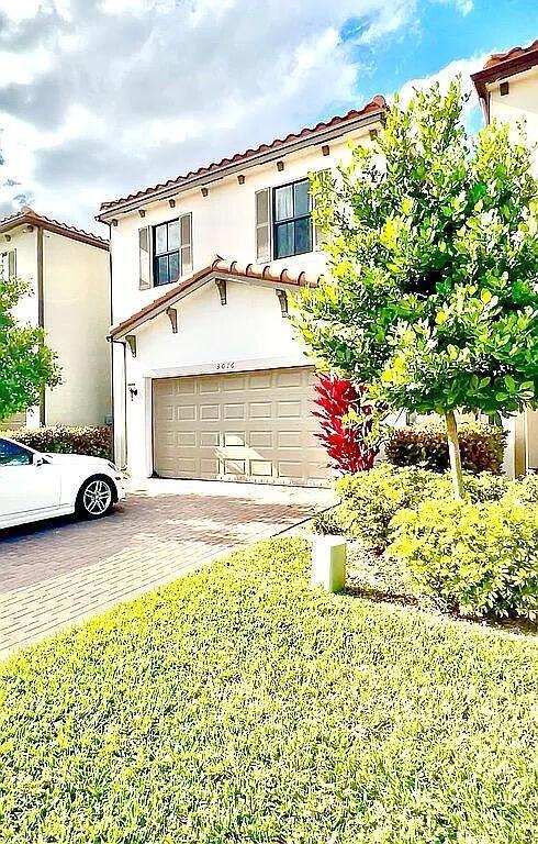 A two-story house with a beige garage and a white car parked in the driveway — 3016 King Palm Way, Riviera Beach FL 33410, RIVIERA BEACH, FL