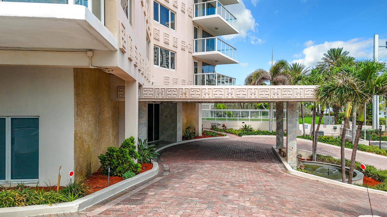 A paved driveway leads to the covered entrance of a multi-story building with balconies — 3000 Holiday Drive # 1505, Fort Lauderdale FL 33316, FORT LAUDERDALE, FL