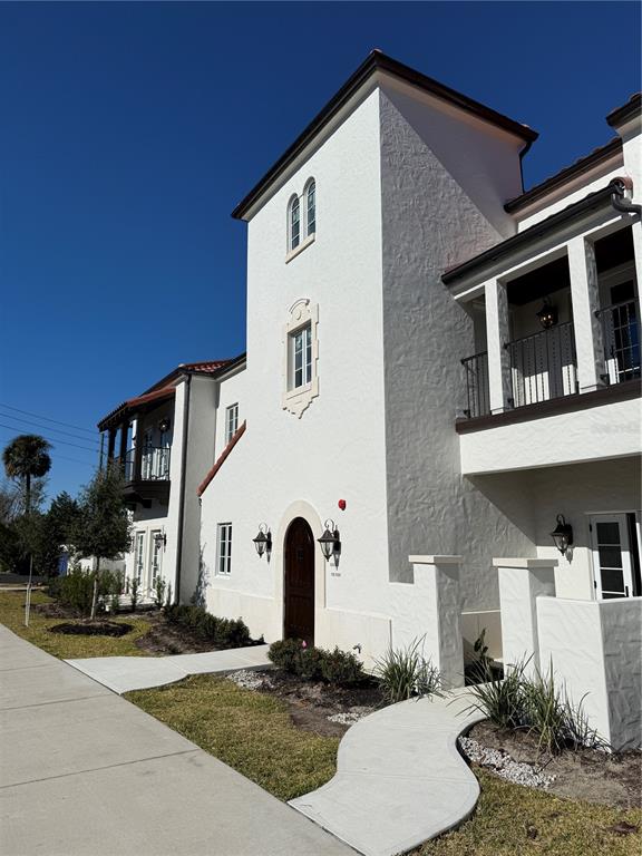 A white stucco building with a tower, arched doorway, and balconies under a clear sky — 301 W COMSTOCK AVENUE, WINTER PARK, FL