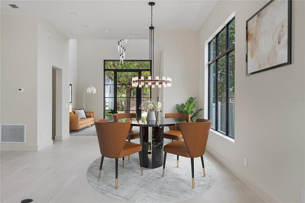 A dining room features a round marble table, four tan chairs, and a modern chandelier — 737 N SUMMERLIN AVENUE, ORLANDO, FL