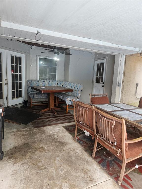 A covered patio features a dining set, a corner bench, and two exterior doors — 18890 SW 44TH STREET, DUNNELLON, FL