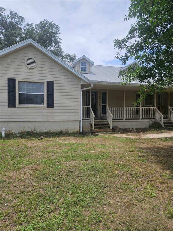 A tan, single-story house with a metal roof and a covered front porch — 18890 SW 44TH STREET, DUNNELLON, FL