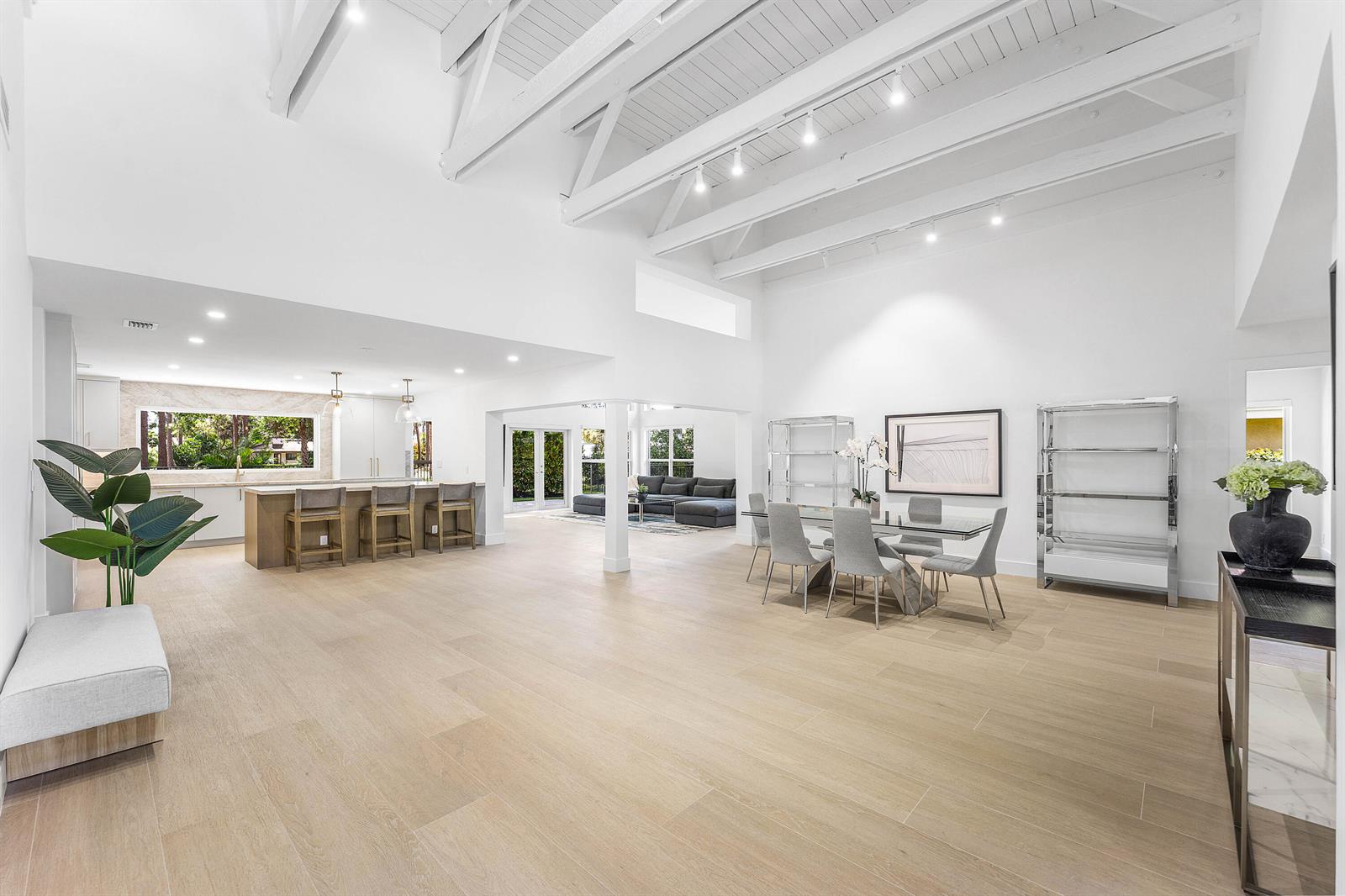 A bright, open-concept living and dining area features vaulted ceilings, light wood floors, and kitchen — 654 W Lakewoode Circle, Delray Beach FL 33445, DELRAY BEACH, FL