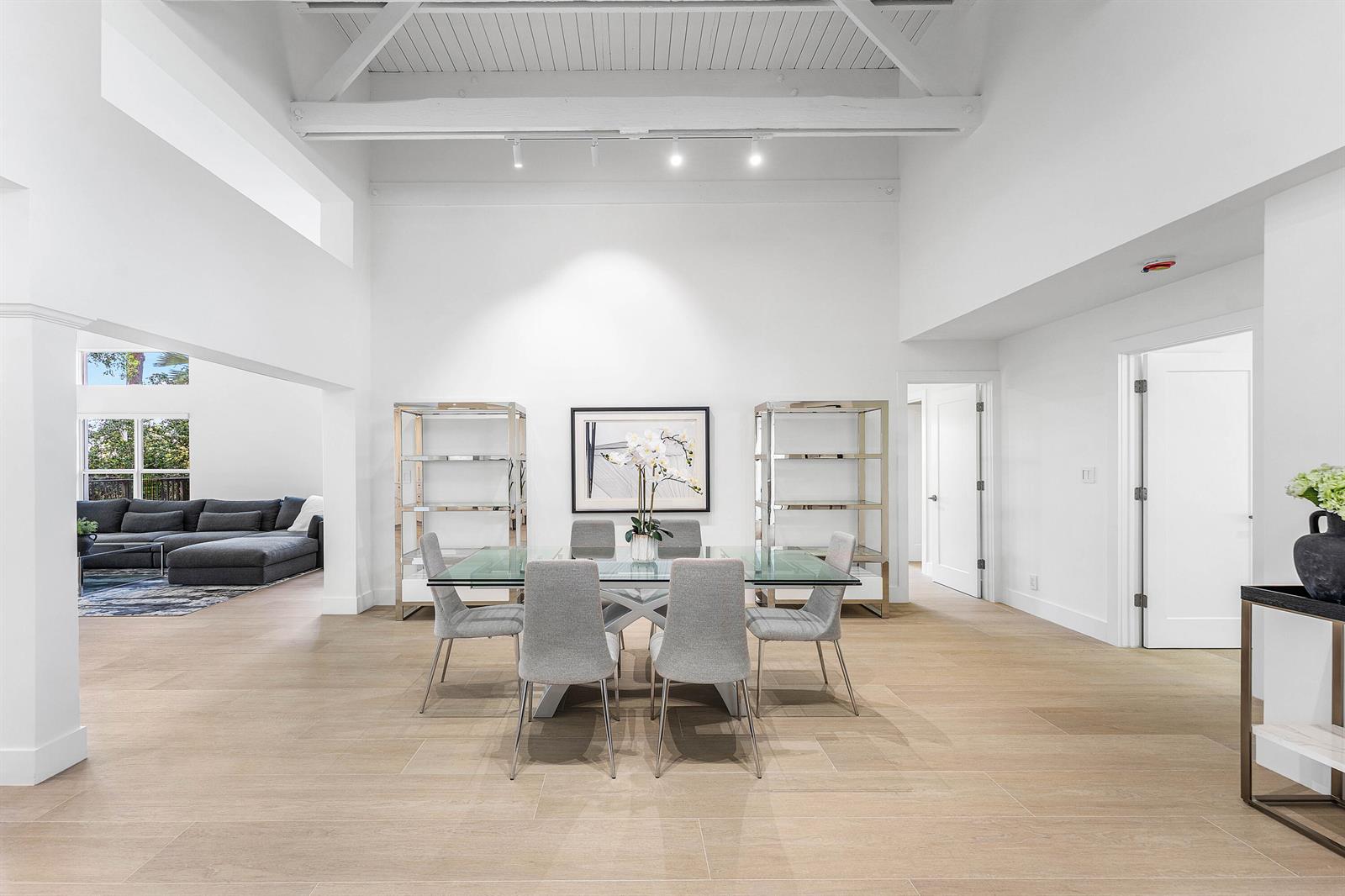 A bright dining room features a glass table, gray chairs, and high vaulted ceilings — 654 W Lakewoode Circle, Delray Beach FL 33445, DELRAY BEACH, FL