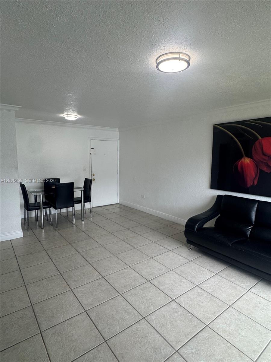 A living room features white walls, tile flooring, a black sofa, and a dining set — 7235 SW 94th Pl # J6, Miami FL 33173, MIAMI, FL