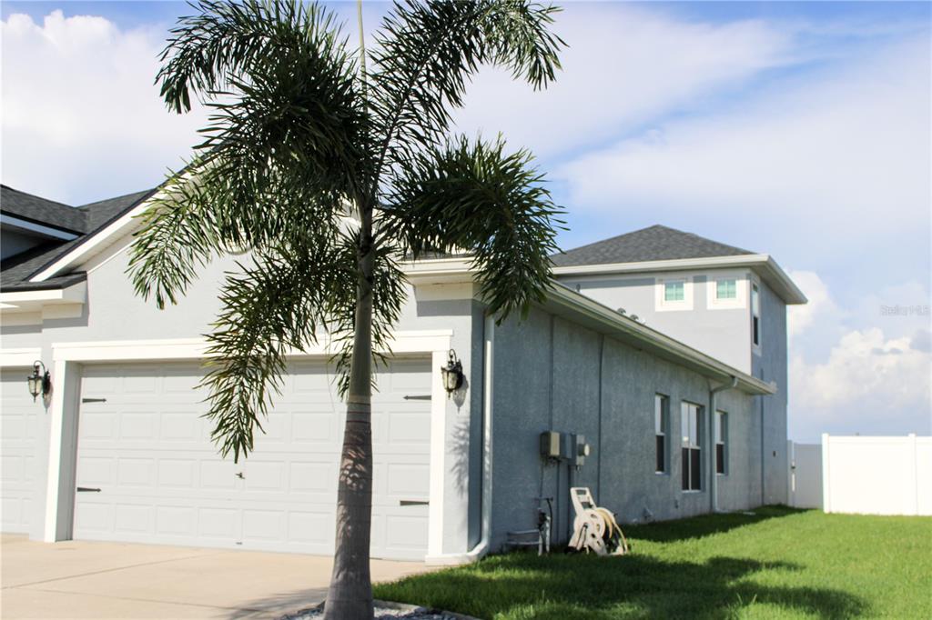A gray two-story house with a palm tree in the front yard and a garage — 433 YORK DALE DRIVE, RUSKIN, FL