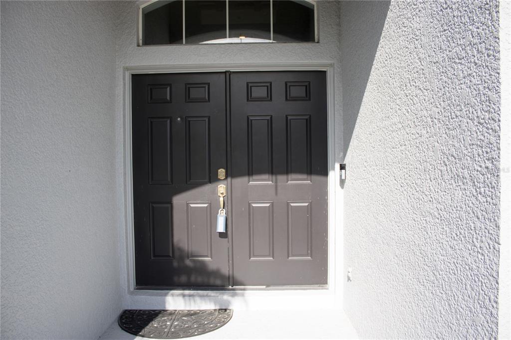A dark brown double front door with a transom window sits in a white entryway — 433 YORK DALE DRIVE, RUSKIN, FL