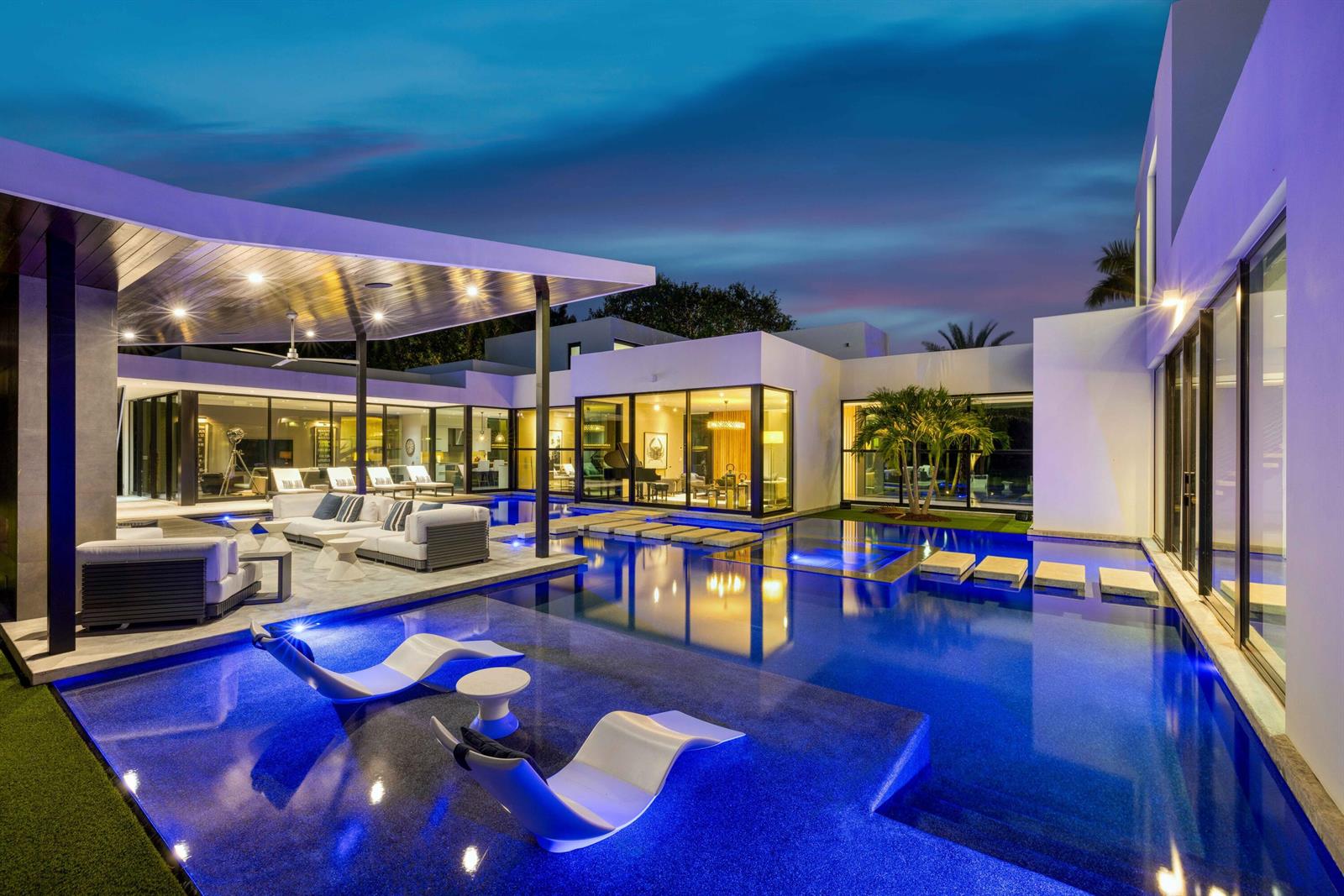 A modern house exterior features a large swimming pool with lounge chairs and stepping stones — 12 N Beach Road, Jupiter Island FL 33455, JUPITER ISLAND, FL