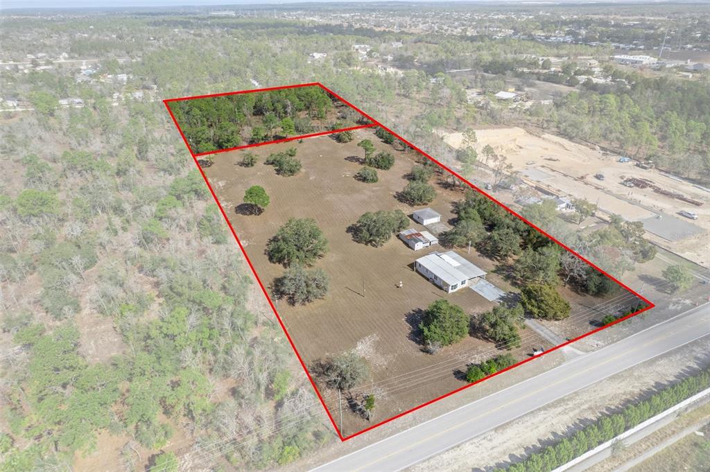 An aerial view shows a rectangular property with a house, outbuildings, and scattered trees — 13255 JACQUELINE ROAD, BROOKSVILLE, FL