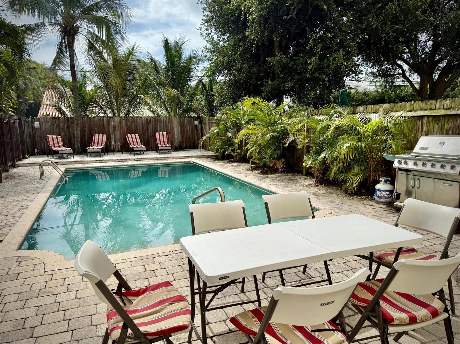 A backyard features a rectangular swimming pool, a patio dining set, and a gas grill — 619 NE 7th Avenue, Delray Beach FL 33483, DELRAY BEACH, FL