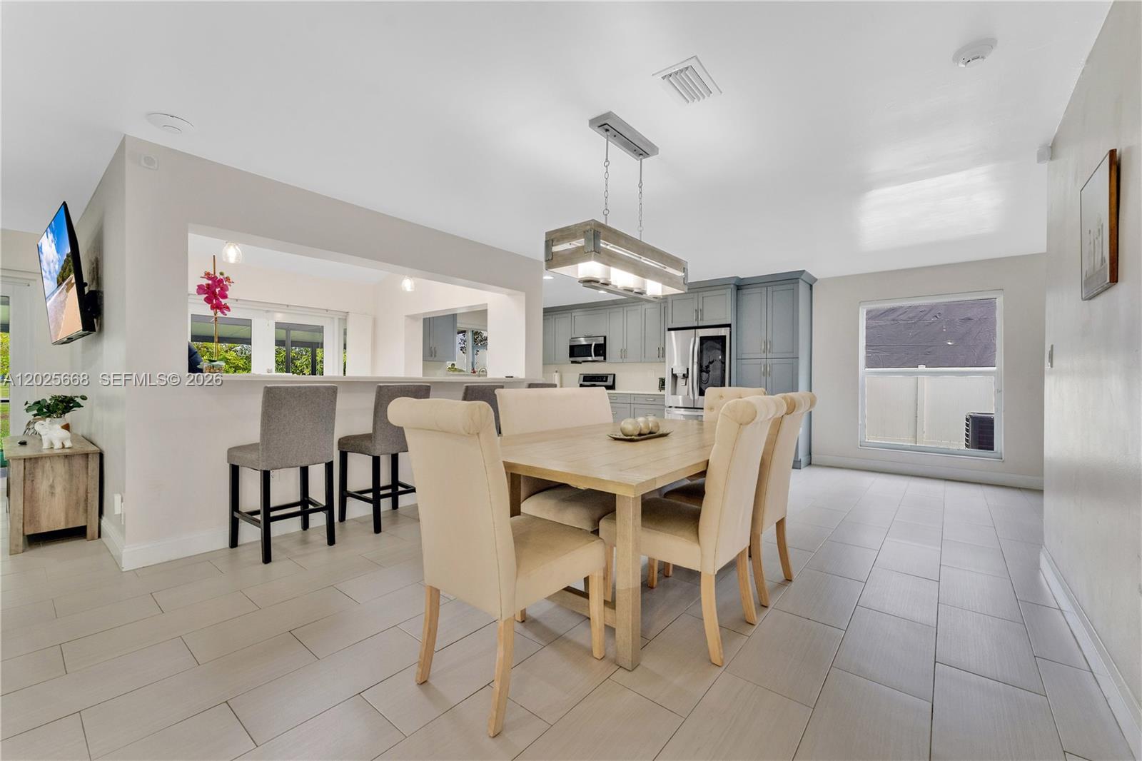 A dining area with a wooden table and chairs sits adjacent to a kitchen — 9501 E Palmetto Club Ln E # 9501, Palmetto Bay FL 33157, PALMETTO BAY, FL
