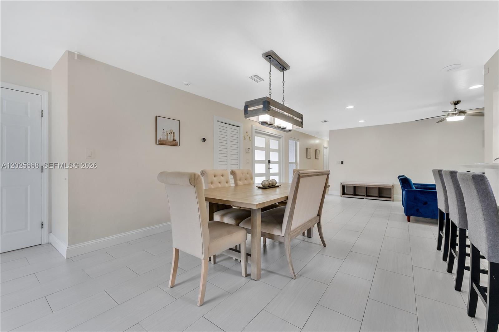 A dining area features a wooden table, upholstered chairs, and a rectangular pendant light fixture — 9501 E Palmetto Club Ln E # 9501, Palmetto Bay FL 33157, PALMETTO BAY, FL