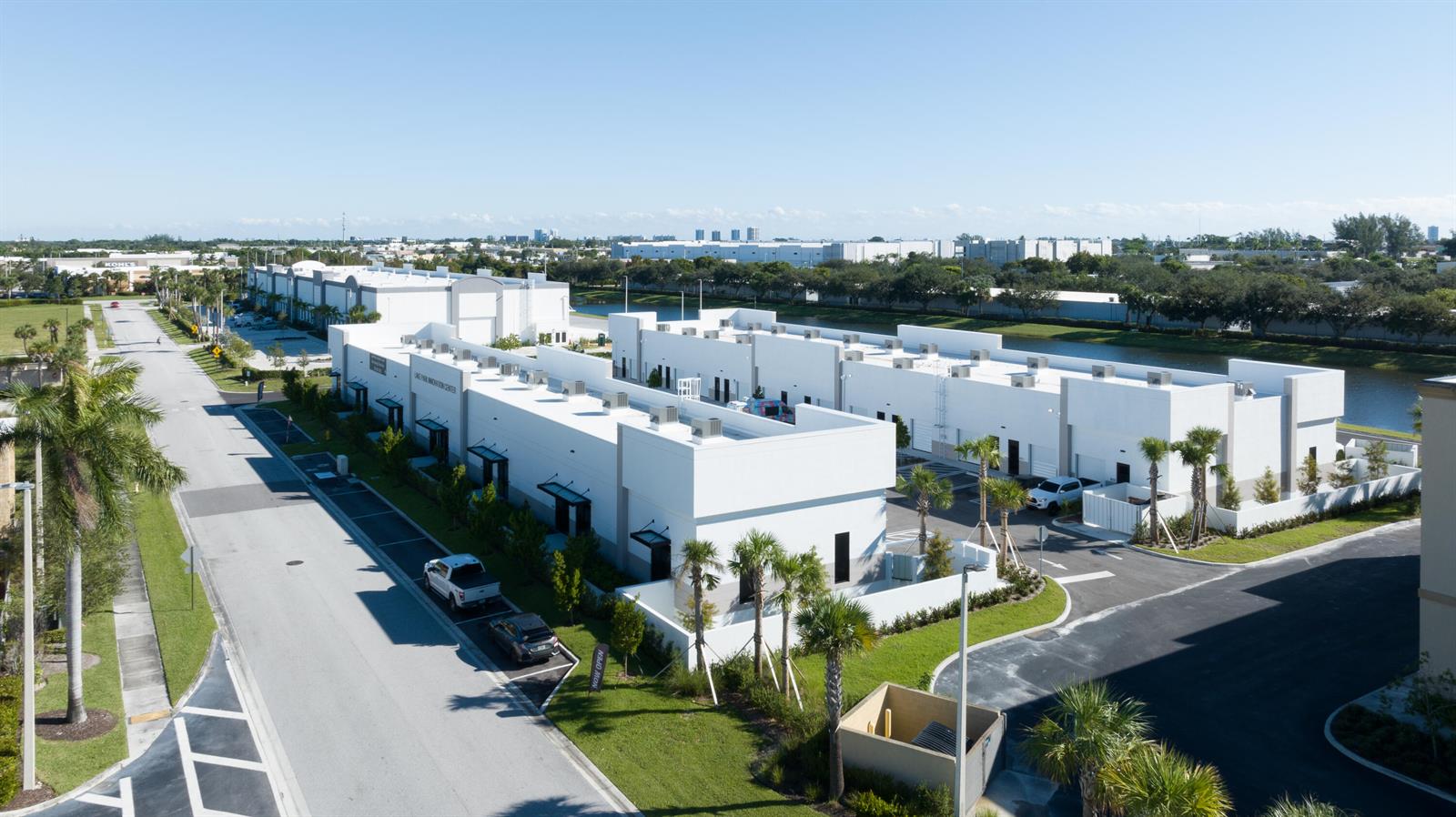 An aerial view shows a modern white commercial building complex with parking and landscaping — 230 N Congress Avenue, Lake Park FL 33403, LAKE PARK, FL