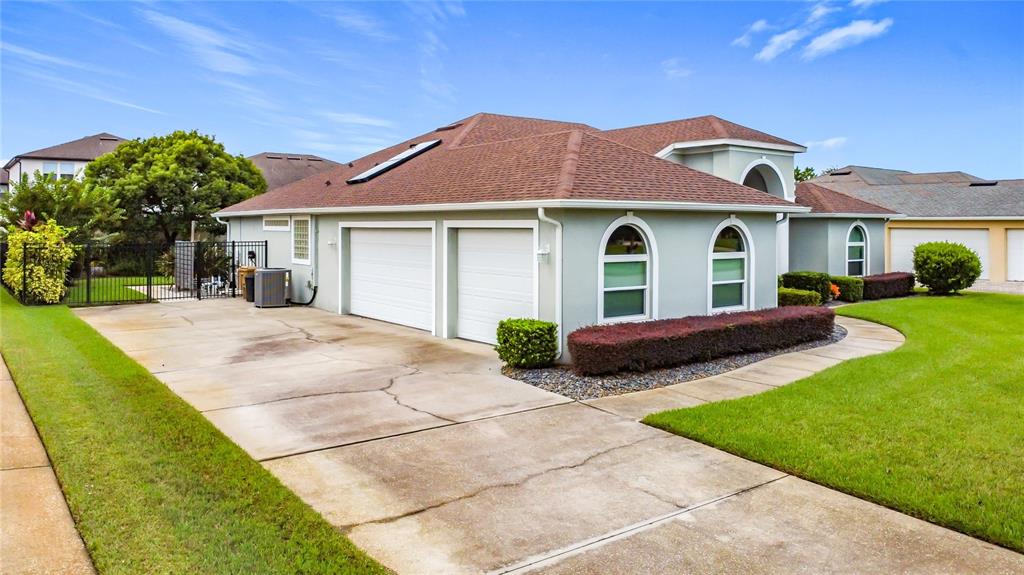 A single-story house with a two-car garage, arched windows, and a concrete driveway — 2808 DEERFIELD STREET, ST CLOUD, FL