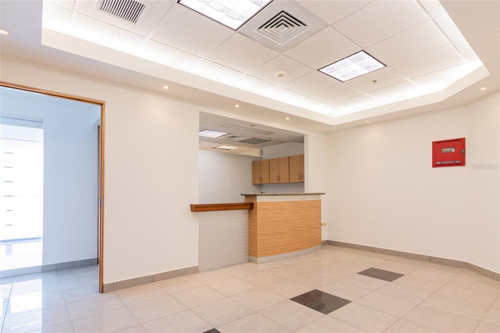 A reception area features a wooden service counter, light tile flooring, and recessed ceiling lighting — 995 METRO MEDICAL CENTER CLL REV DOM MARRERO, BAYAMON, PR