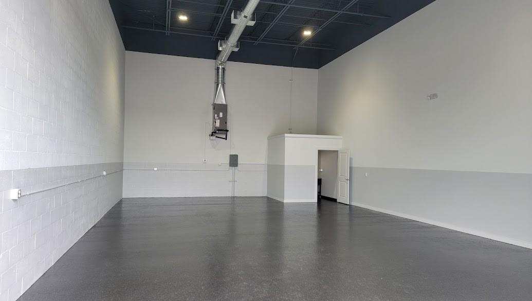 An empty commercial warehouse space with gray epoxy floors, white walls, and an exposed ceiling — 6509 St Lucie Boulevard # 2, Fort Pierce FL 34951, FORT PIERCE, FL