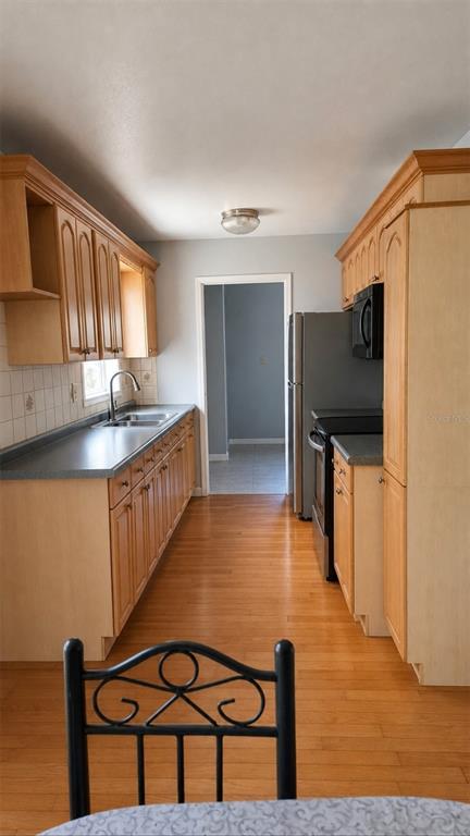 A kitchen features light wood cabinets, gray countertops, stainless steel appliances, and hardwood flooring — 783 CORNELIA COURT, ORLANDO, FL