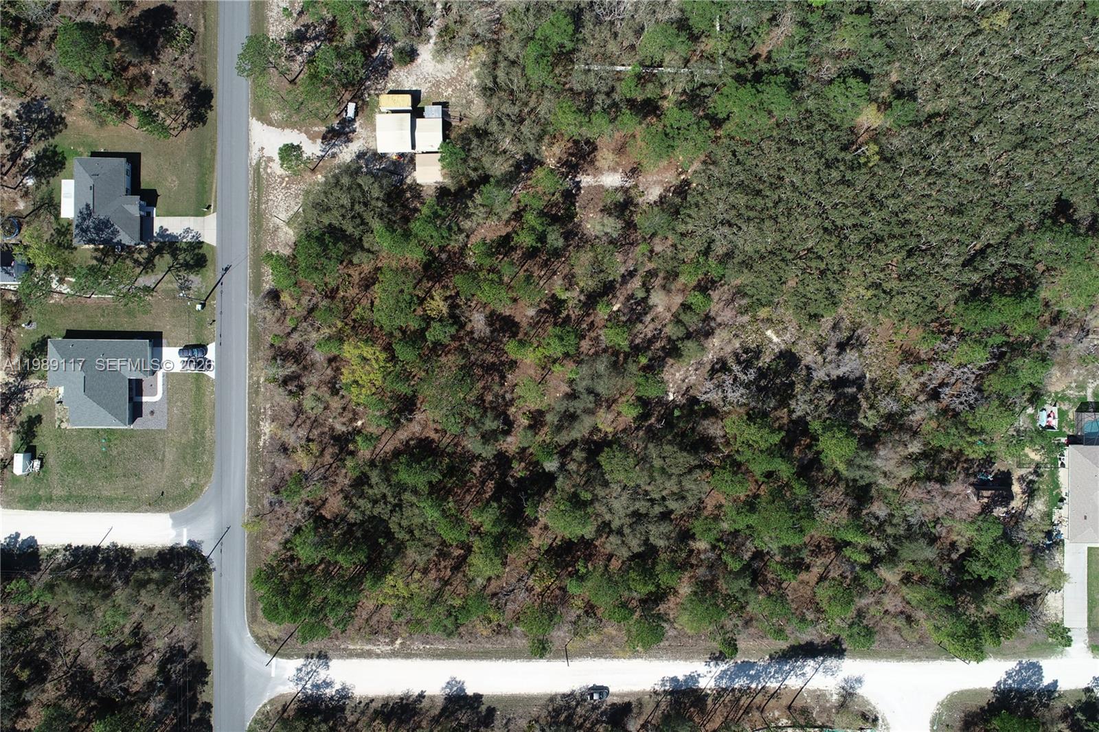 An aerial view shows a wooded, undeveloped rectangular lot situated between two paved roads — 0 Wood Own Ave and Malibar Rd, Other City - In The State Of Florida FL 34614, OTHER CITY - IN THE STATE OF FLORIDA, FL