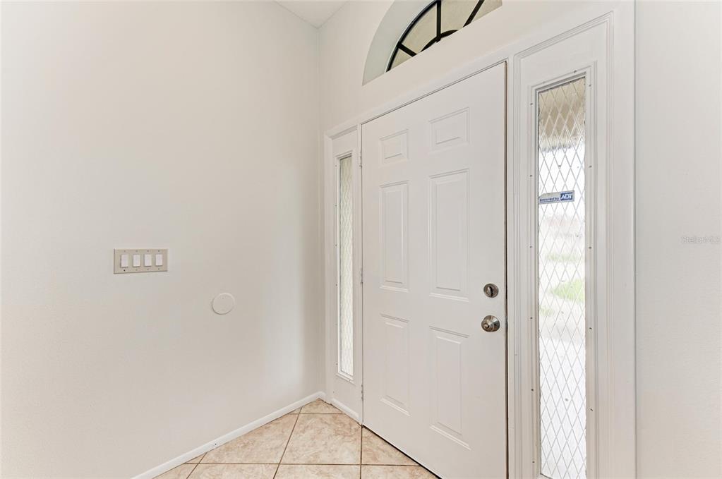 An entryway features a white front door with sidelights, tile flooring, and a light switch — 4621 35TH COURT E, BRADENTON, FL
