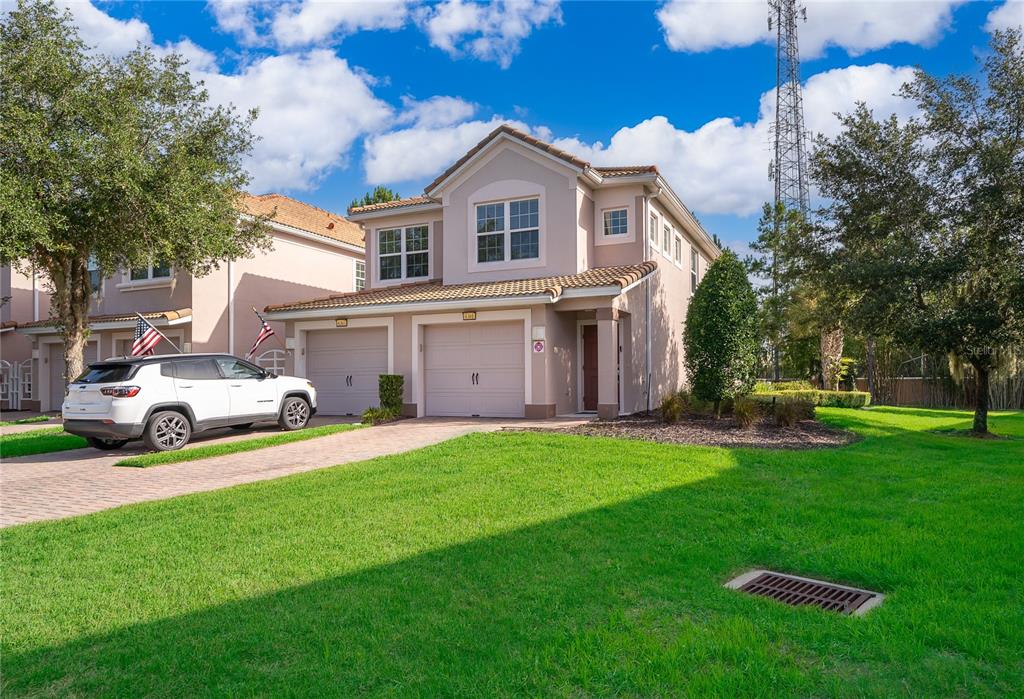 A two-story suburban house with a two-car garage, a paved driveway, and a grassy lawn — 8301 BELLA VIDA CIRCLE UNIT 8301, DAVENPORT, FL