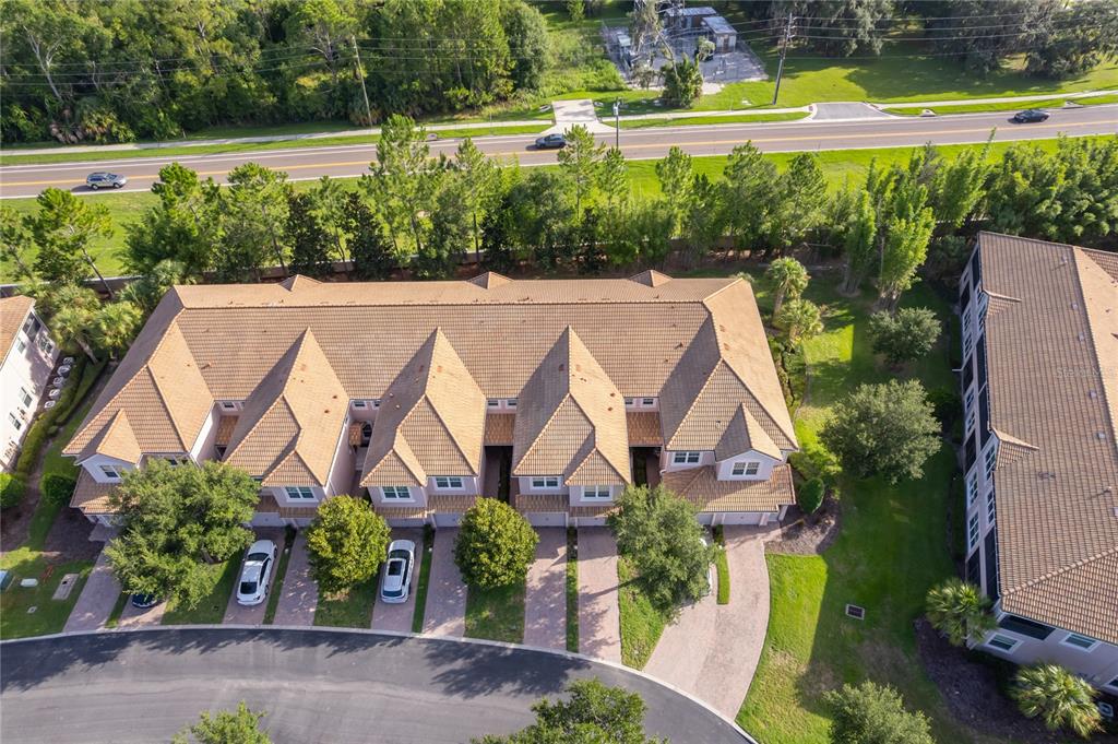 An aerial view shows a multi-unit townhouse building with a tiled roof and paved driveways — 8301 BELLA VIDA CIRCLE UNIT 8301, DAVENPORT, FL