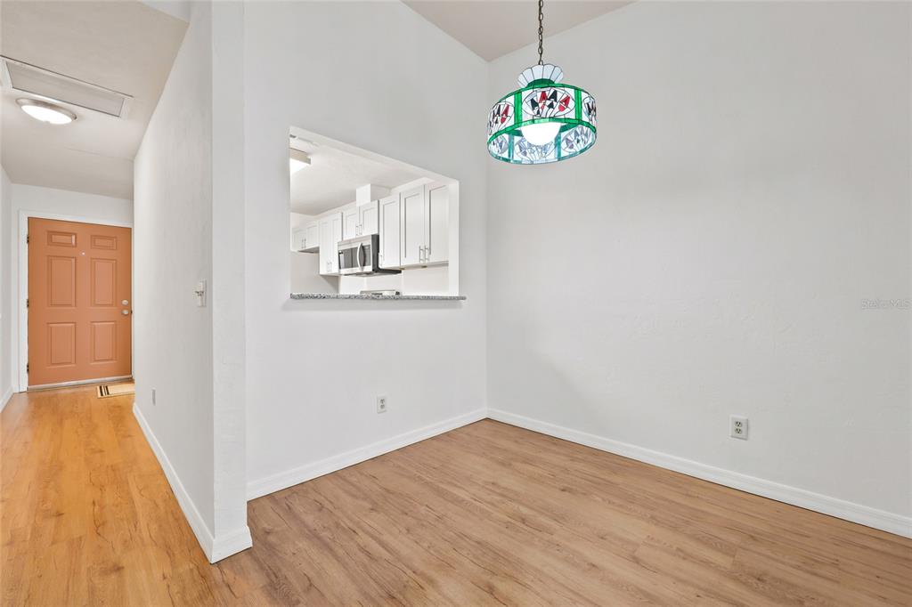 A dining area features light wood flooring, white walls, and a stained-glass pendant light fixture — 3405 NW 52ND TERRACE, GAINESVILLE, FL