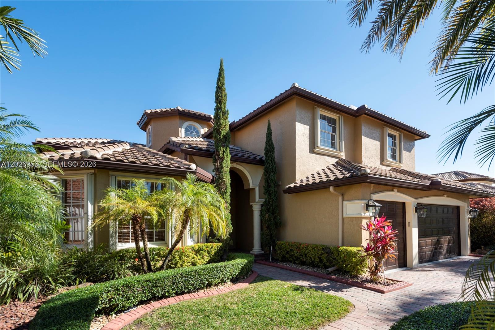 A two-story stucco house features a tile roof, arched entryway, and a paved driveway — 18991 SW 32nd St, Miramar FL 33029, MIRAMAR, FL
