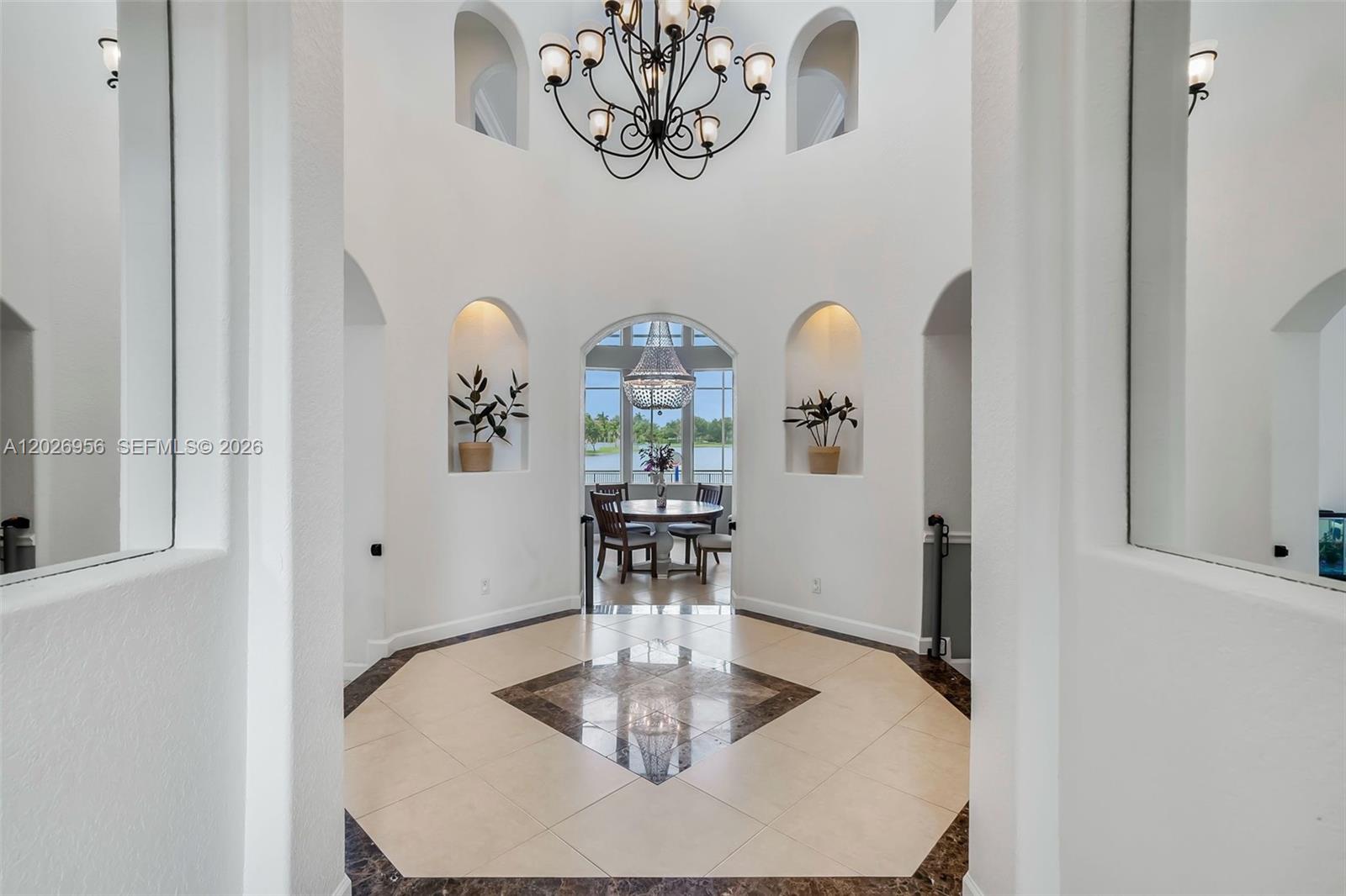 A bright, circular foyer features a chandelier, tiled floor, and arched wall niches — 18991 SW 32nd St, Miramar FL 33029, MIRAMAR, FL