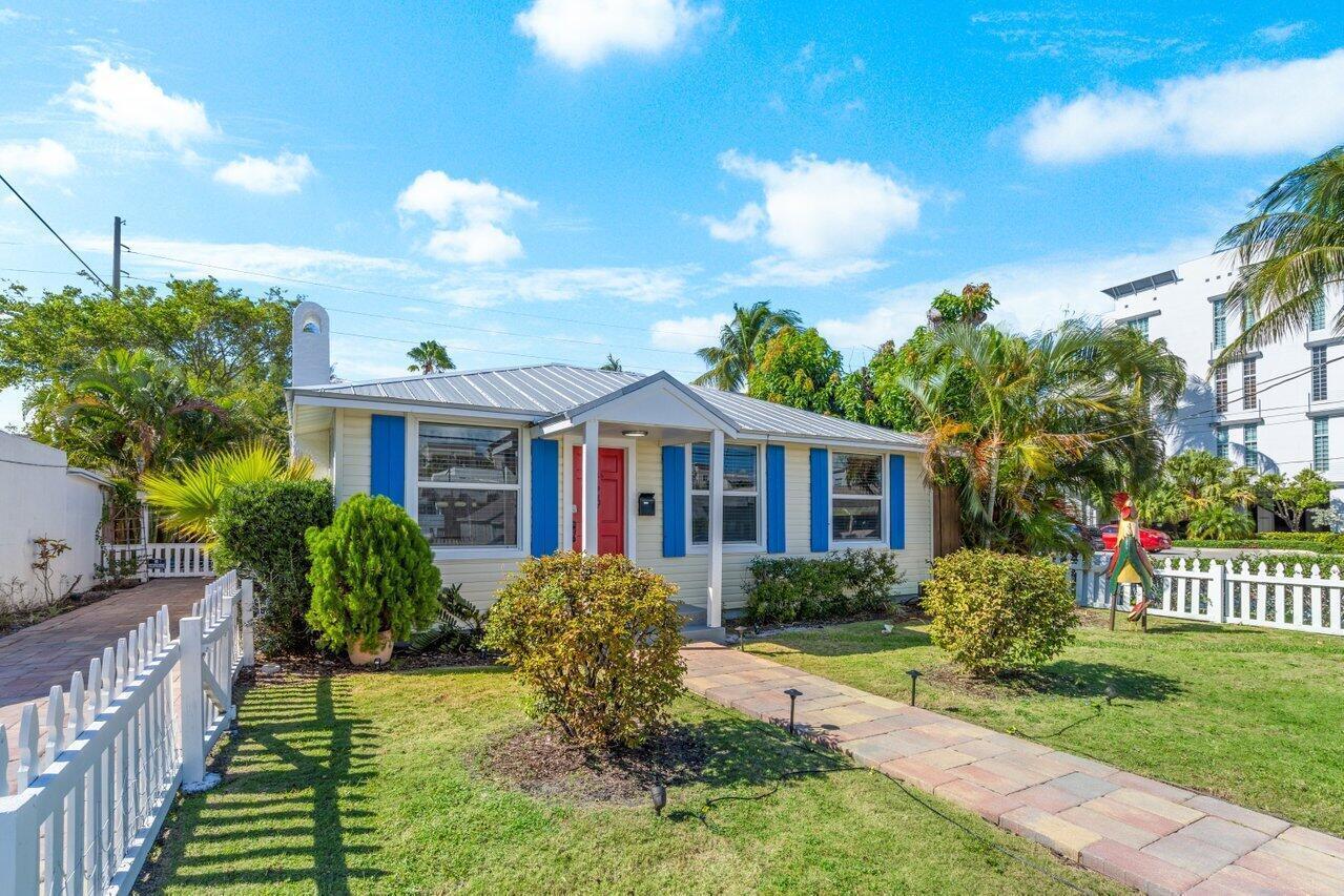 A single-story house with light siding, blue shutters, a red door, and a metal roof — 126 NE 4th Avenue, Delray Beach FL 33483, DELRAY BEACH, FL