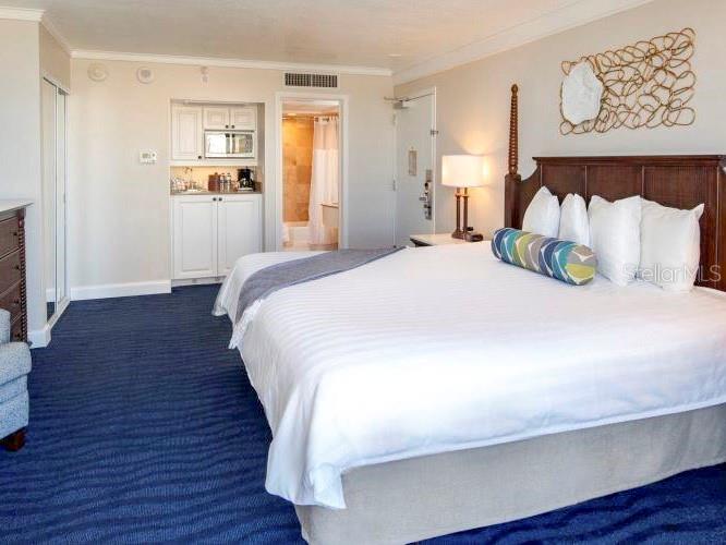 A hotel room features a large bed, a kitchenette, and a bathroom entrance — 5500 GULF BOULEVARD UNIT 4256, ST PETERSBURG, FL