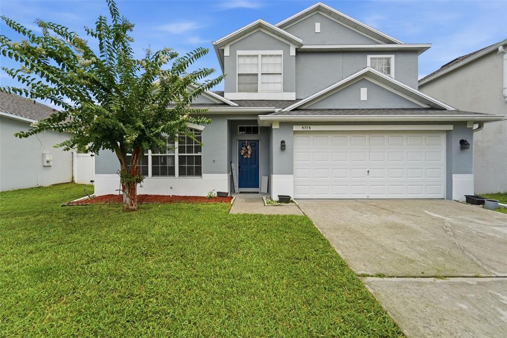 A two-story gray house with a blue front door and a two-car garage — 9773 BENNINGTON CHASE DRIVE, ORLANDO, FL