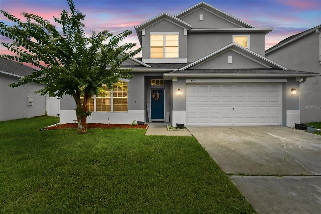 A two-story gray house with a white garage, a blue front door, and a front lawn — 9773 BENNINGTON CHASE DRIVE, ORLANDO, FL