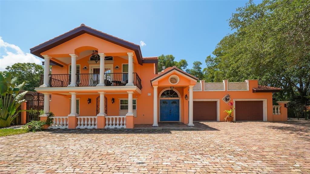 A two-story orange house with a brick driveway, a balcony, and a two-car garage — 2520 TAMI SOLA STREET, SARASOTA, FL