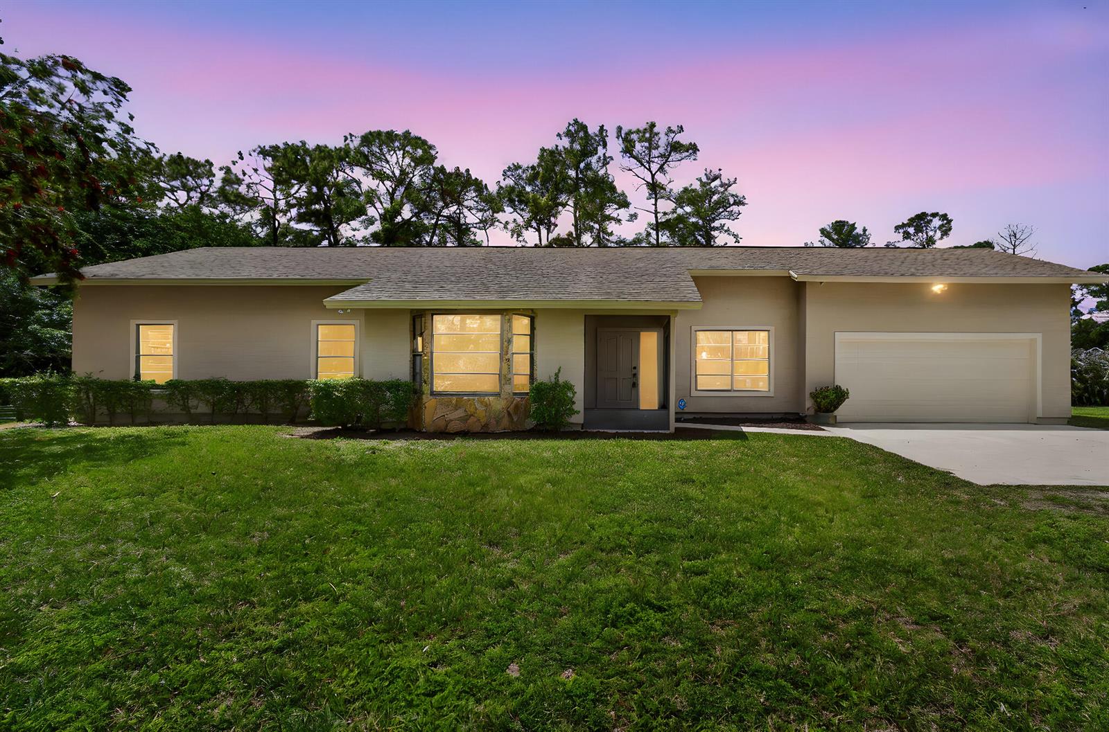 A single-story house with a beige exterior, a two-car garage, and a large front lawn — 6045 Hall Boulevard, FL 33470, FL